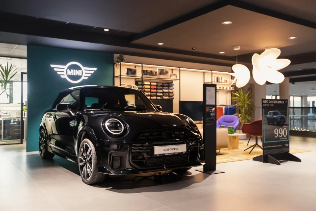 MINI Cooper w salonie MINI M-Cars, ekspozycja auta na tle logo MINI i strefy klienta