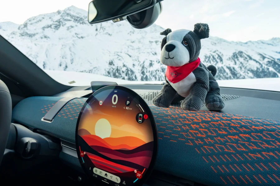 Wnętrze MINI z pluszową maskotką na desce rozdzielczej, zimowe góry w tle, akcesoria MINI Lifestyle