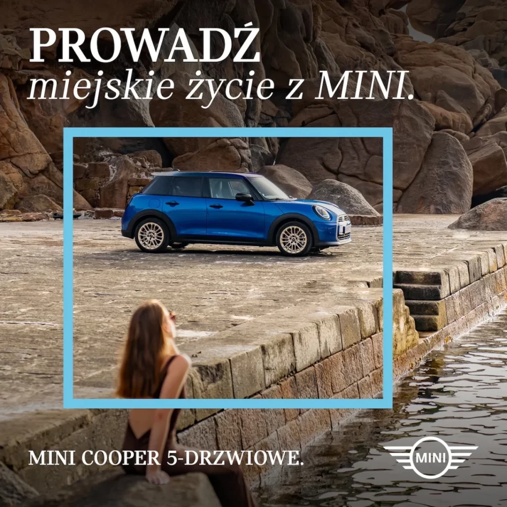 Niebieskie MINI Cooper 5-drzwiowe na kamiennym nabrzeżu przy skałach i wodzie, kadr z hasłem „Prowadź miejskie życie z MINI”. MINI M-Cars Kraków, Małopolska.
