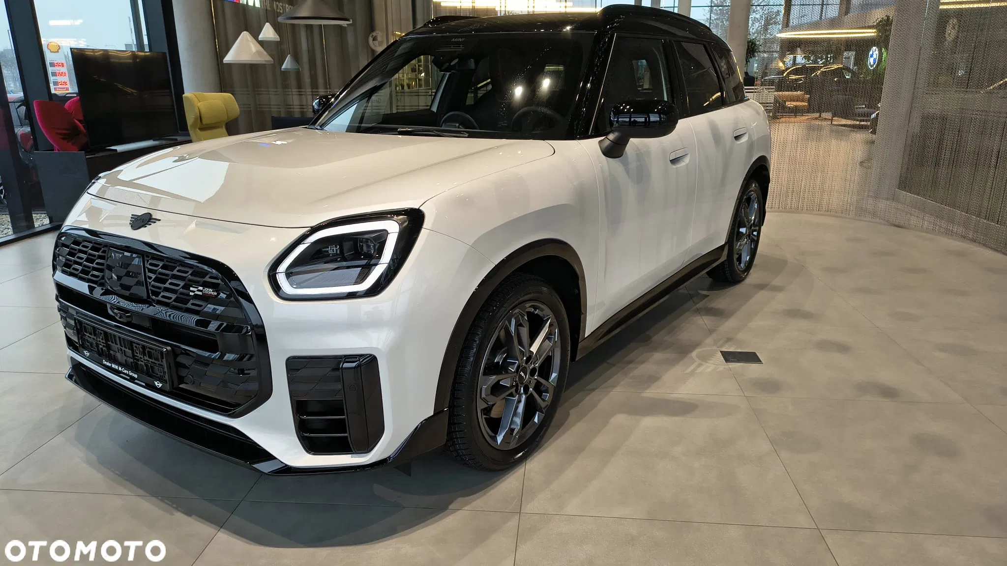Białe MINI Countryman w salonie, ujęcie przód-bok, czarny grill i detale nadwozia. MINI M-Cars Kraków, Małopolska