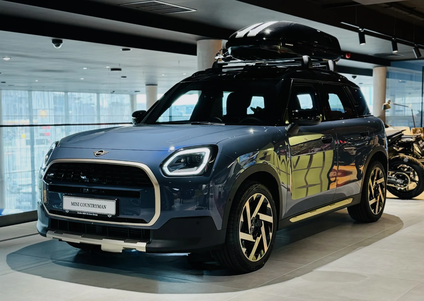 MINI Countryman Electric w salonie M-Cars Kraków z boxem dachowym, widok przód bok