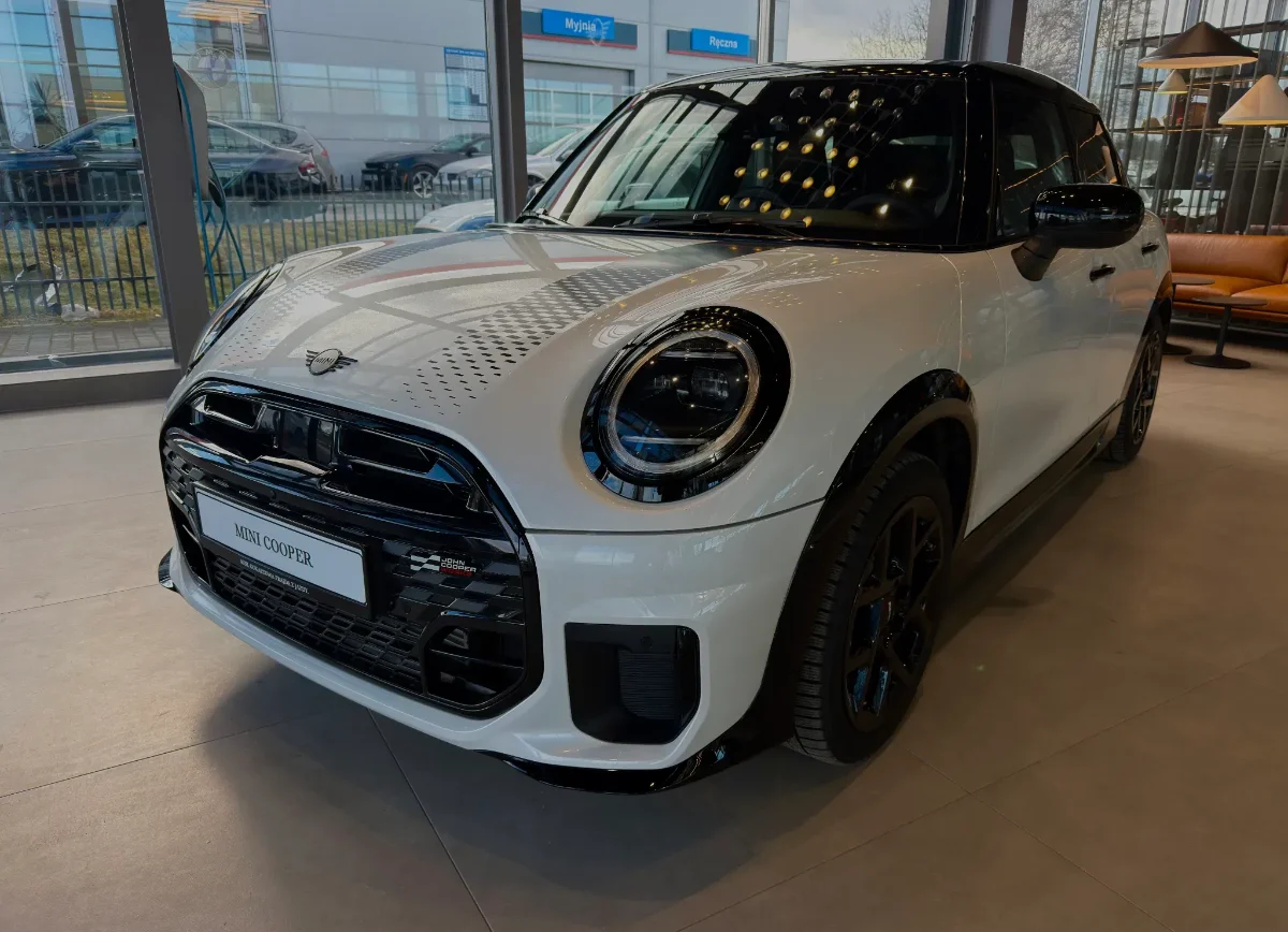 Jasne MINI Countryman w salonie, ujęcie przód-bok, przestronna strefa lounge w tle. Samochody MINI Kraków, Małopolska