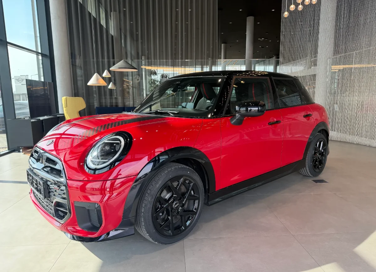 Jasne MINI Countryman w salonie, ujęcie przód-bok, przestronna strefa lounge w tle. Samochody MINI Kraków, Małopolska