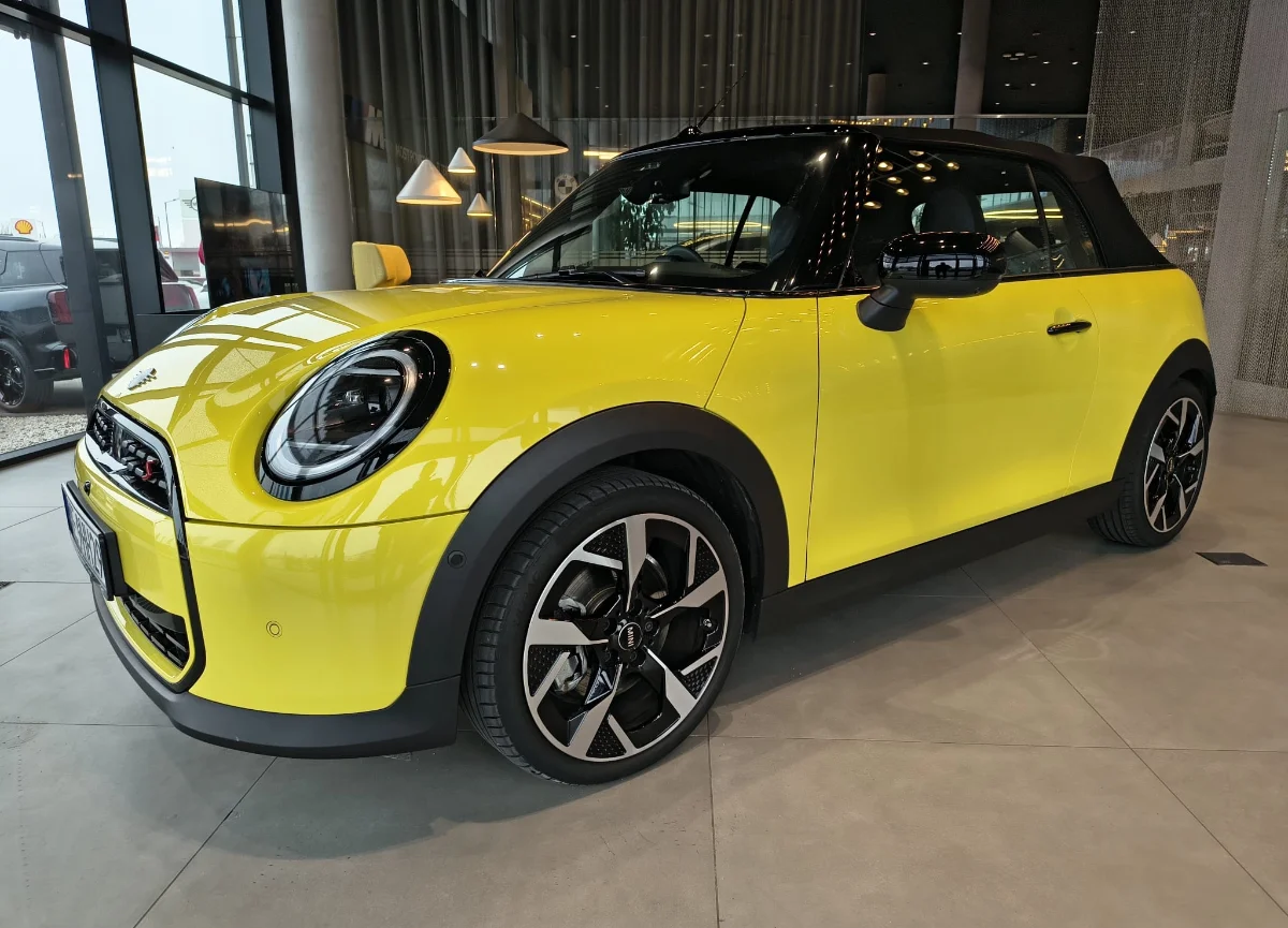 Jasne MINI Countryman w salonie, ujęcie przód-bok, przestronna strefa lounge w tle. Samochody MINI Kraków, Małopolska