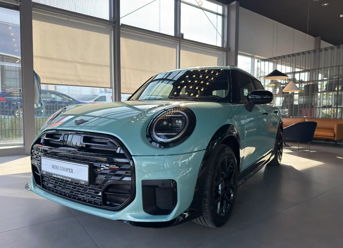 Jasne MINI Countryman w salonie, ujęcie przód-bok, przestronna strefa lounge w tle. Samochody MINI Kraków, Małopolska