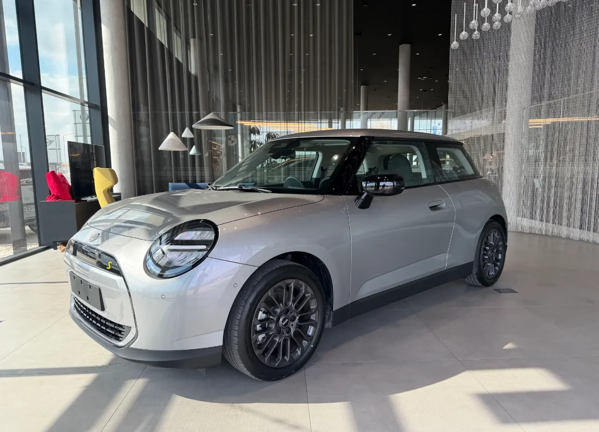 Jasne MINI Countryman w salonie, ujęcie przód-bok, przestronna strefa lounge w tle. Samochody MINI Kraków, Małopolska