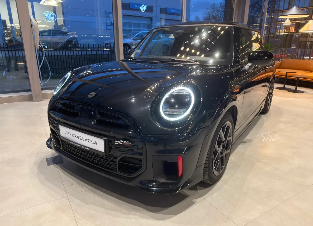 Jasne MINI Countryman w salonie, ujęcie przód-bok, przestronna strefa lounge w tle. Samochody MINI Kraków, Małopolska