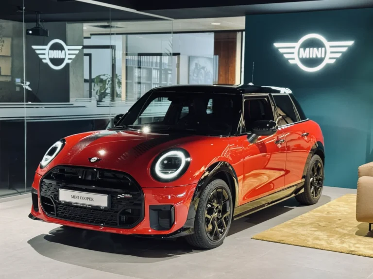 Czerwony MINI Cooper w salonie MINI M-Cars Kraków, prezentowany przy podświetlanym logo MINI; samochody MINI w Krakowie.