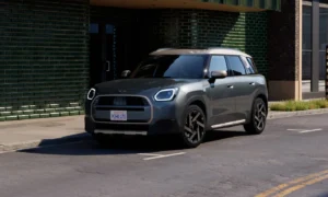 Nowe MINI Countryman ONE na miejskiej ulicy. Widok z przodu i boku podkreślający nowoczesną stylistykę oraz przestronne nadwozie SUV.