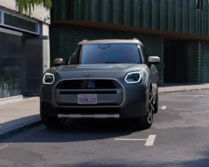 Nowe MINI Countryman ONE w wersji SUV prezentowane od przodu na miejskiej ulicy. Przestronne nadwozie i nowoczesny design modelu.